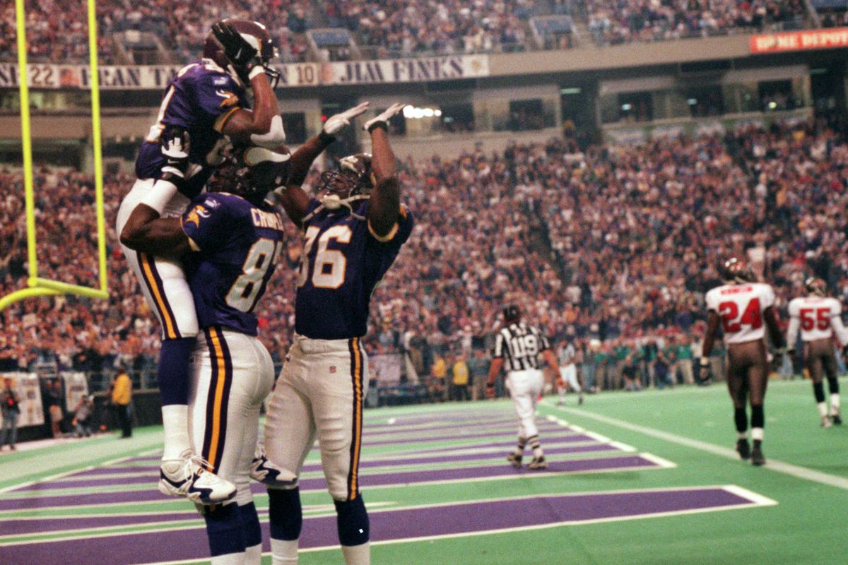 Minneapolis, MN 10/3/99 Vikings vs. Tampa Bay Buccaneers — Randy Moss is congratulated by receiver Jake reed, right, as he is lifted in the air by tight end Carlester Crumpler after Moss scored his first touchdown of the fgame, early in the first quarter