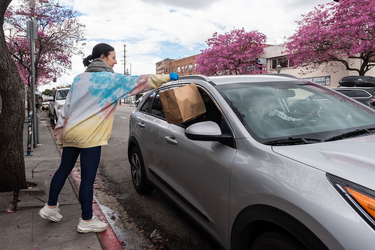 Jessica Koslow drops food into a car outside her restaurant Sqirl in Virgil Village.