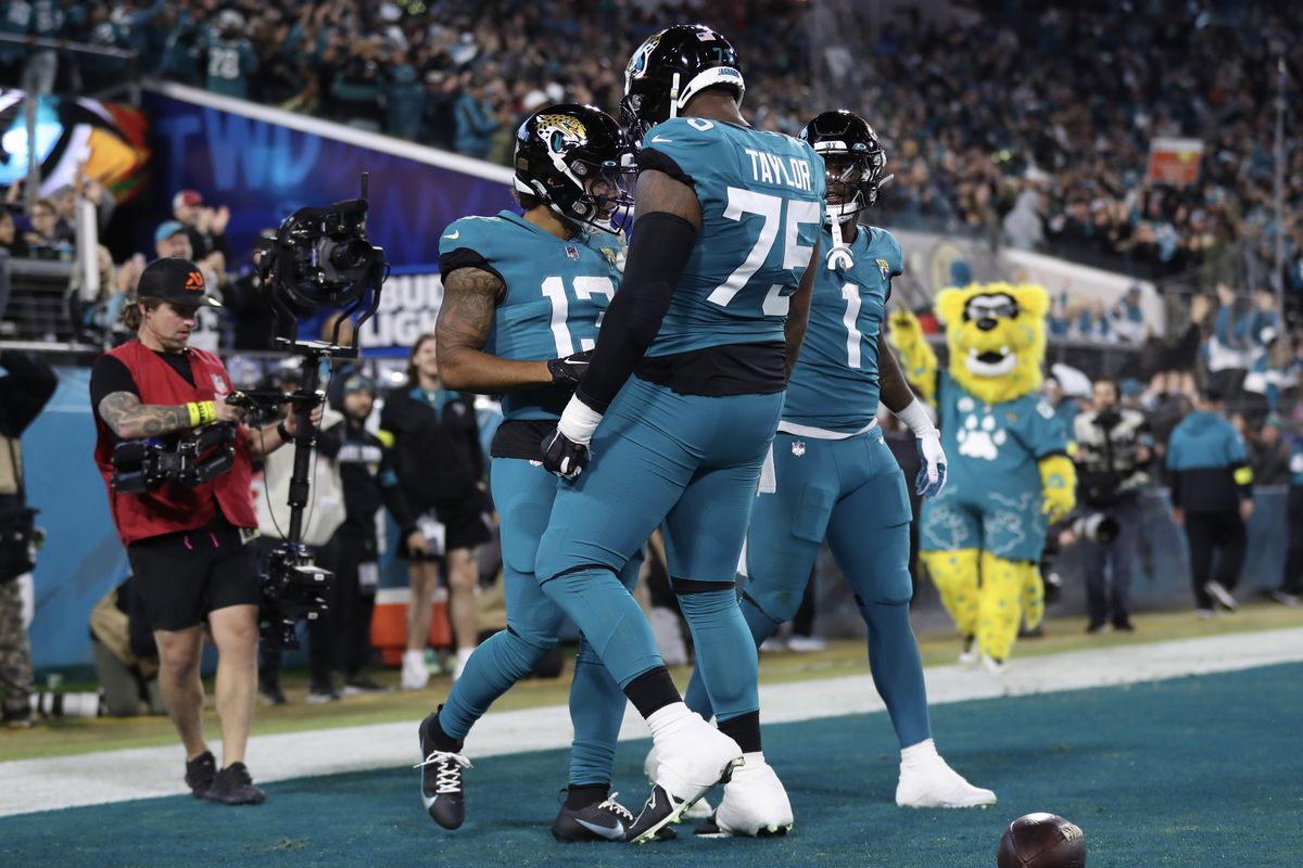 Christian Kirk #13 of the Jacksonville Jaguars celebrates a touchdown with Jawaan Taylor #75 and Travis Etienne Jr. #1 during the first half against the Tennessee Titans at TIAA Bank Field on January 07, 2023 in Jacksonville, Florida.