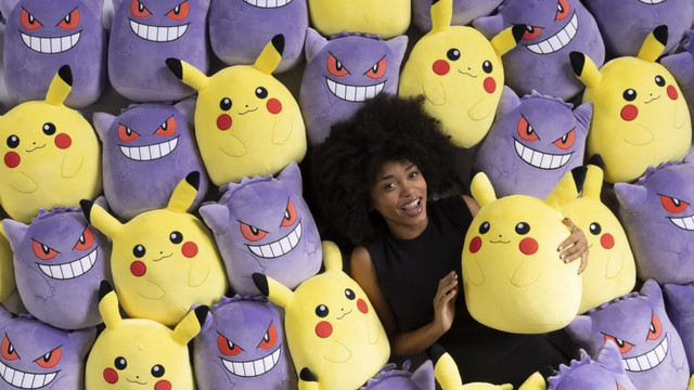 A person laying in a sea of Pokémon Squishmallows