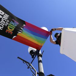 Justin Motley repairs Pride flags hanging in Heber City on Monday, June 10, 2019.