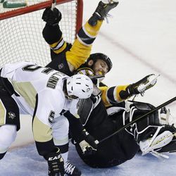 Boston Bruins left wing Milan Lucic, top rear, is upended by Pittsburgh Penguins defenseman Deryk Engelland (5), and falls onto goalie Tomas Vokoun during overtime in Game 3 of the NHL hockey Stanley Cup playoffs Eastern Conference finals, in Boston on Wednesday, June 5, 2013. (AP Photo/Charles Krupa)