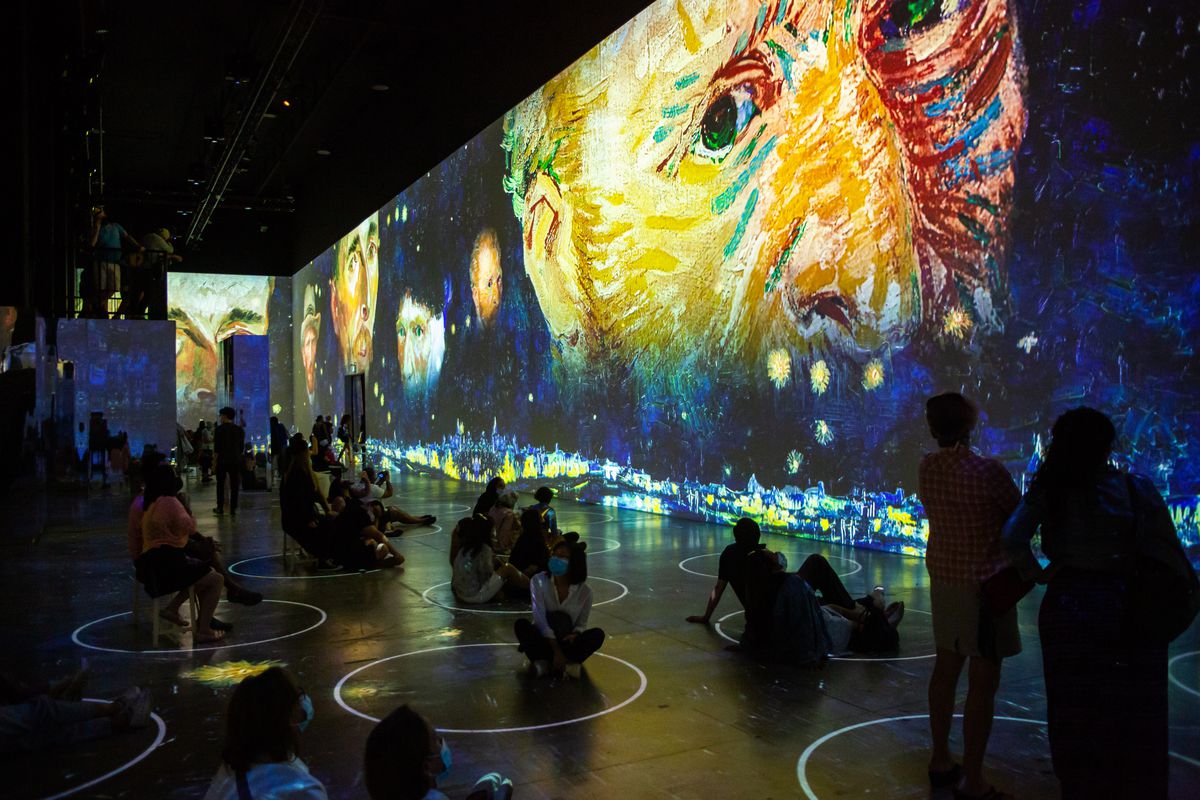 Visitors are surrounded by projections at “Immersive Van Gogh.”