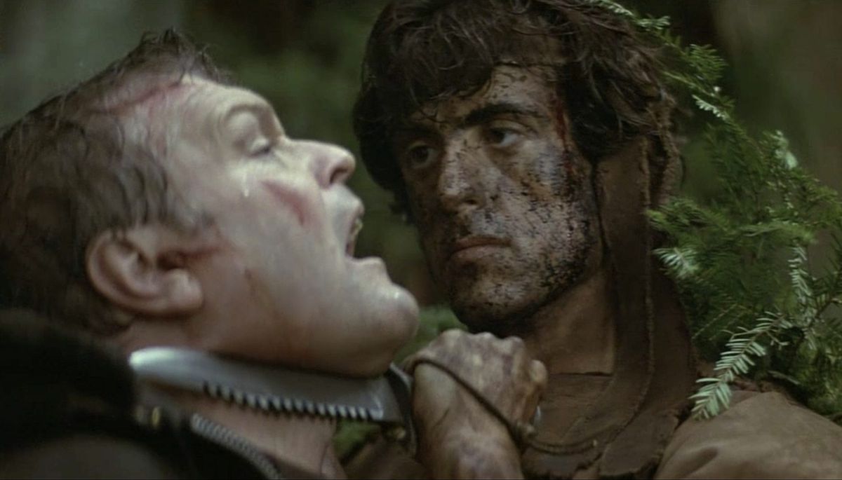 Sylvester Stallone as John Rambo holds a knife to Brian Dennehy’s throat in First Blood.