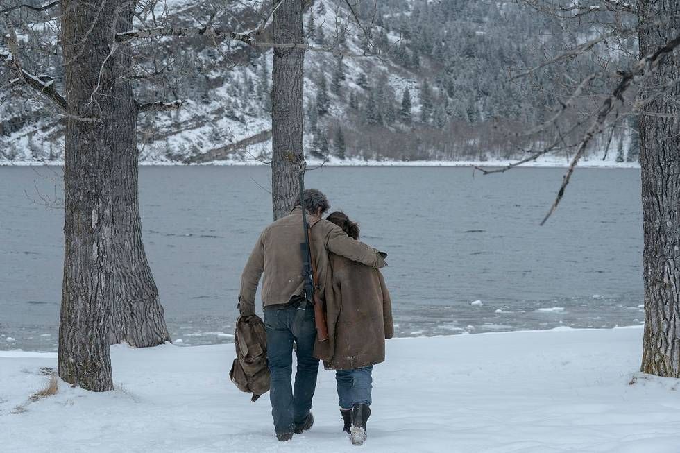 Joel (Pedro Pascal) hugging Ellie (Bella Ramsey) as they walk away from the camera
