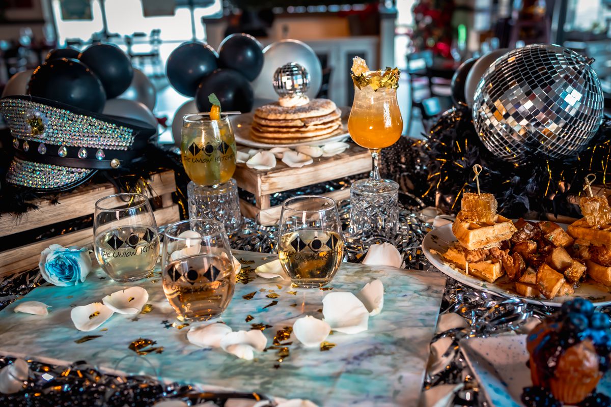 A Union Kitchen spread of Beyoncé-themed food and drinks, including chicken and waffle sliders topped with honeycomb, glittery pancakes topped with a disco ball, and honey-laced cocktails.