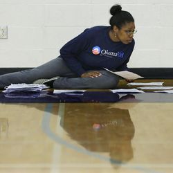 Caucus volunteer Akilah Stewart sorts caucus registration forms by precinct, Saturday, March 26, 2016, at Garfield High School in Seattle.  Democrats caucused statewide in support of either Hillary Clinton or Bernie Sanders. 