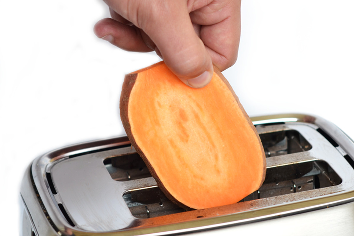 Slices of sweet potato being inserted into a toaster