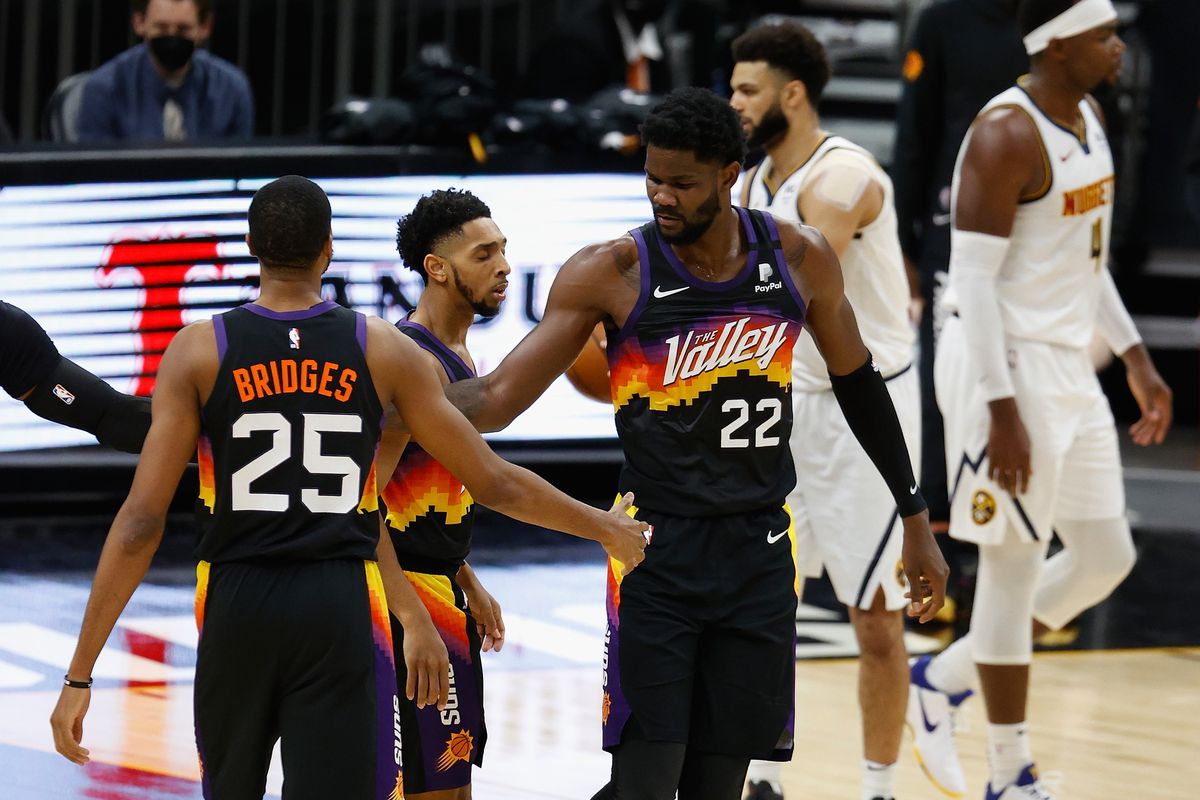 Deandre Ayton of the Phoenix Suns high fives Mikal Bridges after scoring against the Denver Nuggets during the first half of the NBA game at Phoenix Suns Arena on January 23, 2021 in Phoenix, Arizona.