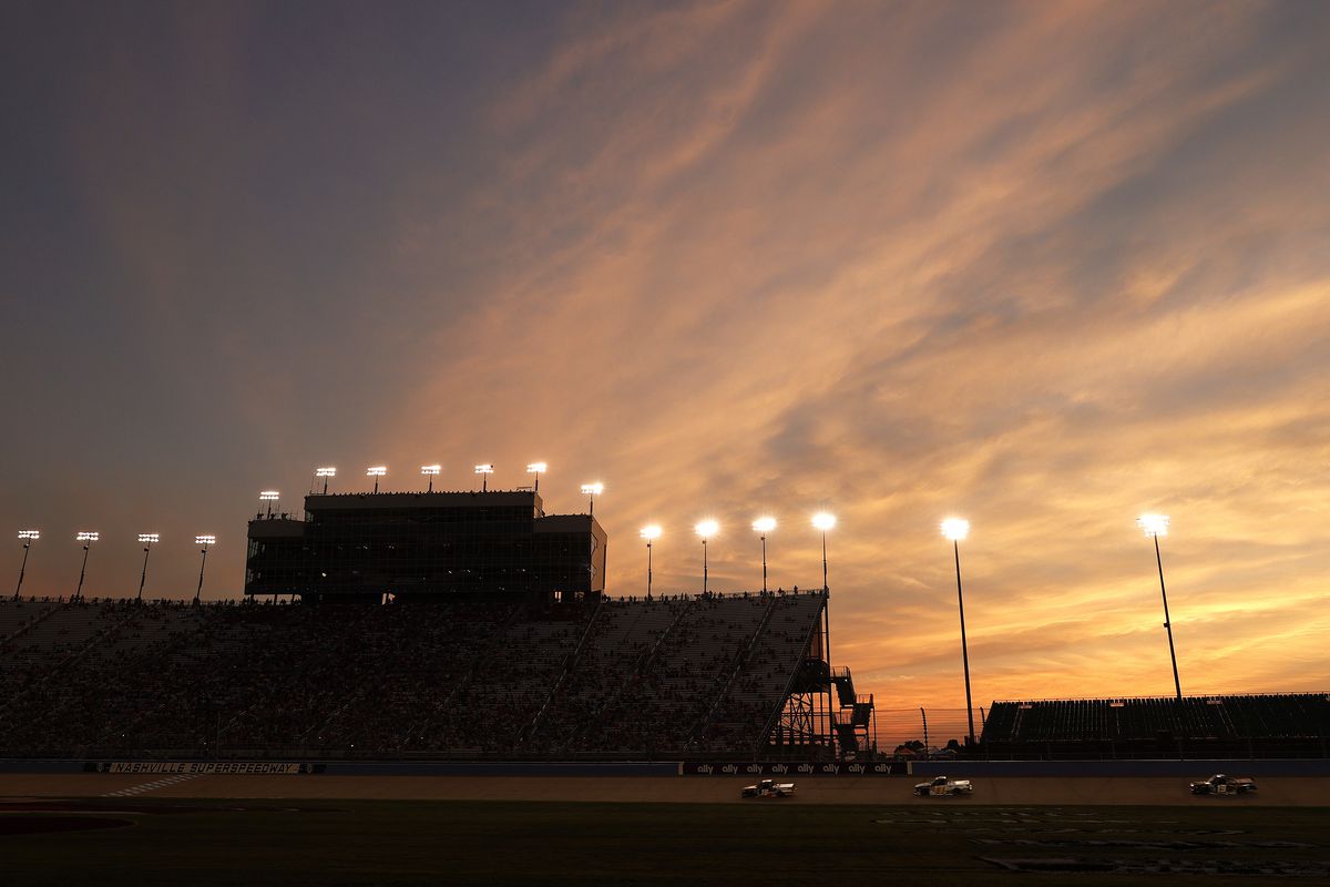 Trucks race as the sun sets during the NASCAR Camping World Truck Series Rackley Roofing 200 at Nashville Superspeedway on June 18, 2021 in Lebanon, Tennessee.