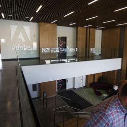 Adobe employees walk through one of the entrances to the office spaces at Adobe in Lehi on Thursday, July 13, 2017. There are many areas inside the building that have relaxing atmospheres for employees to take breaks or work in different spaces.