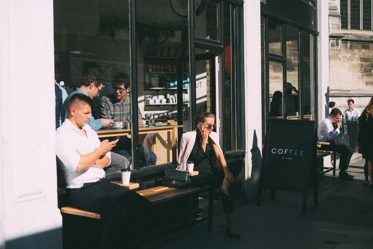 Customers sit outside Rosslyn Coffee in London in 2018