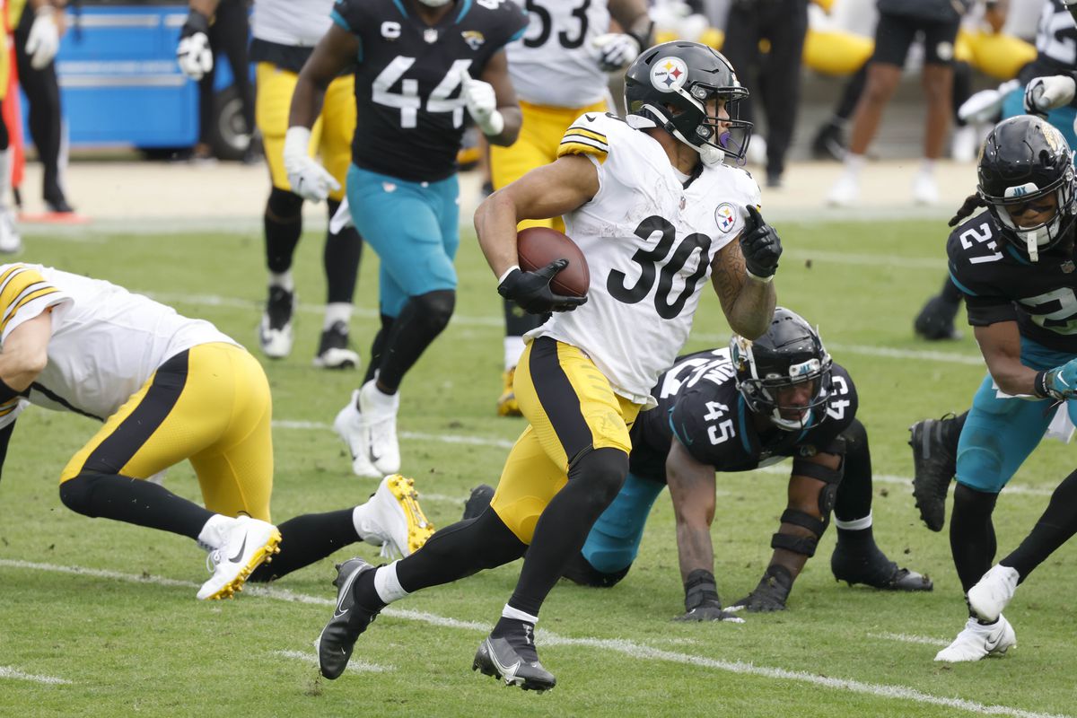 Pittsburgh Steelers running back James Conner (30) runs past Jacksonville Jaguars defensive end K’Lavon Chaisson (45) and cornerback Chris Claybrooks (27) during the second quarter at TIAA Bank Field.