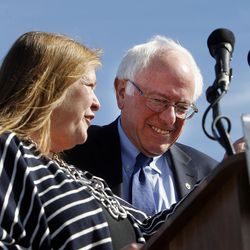 Democratic presidential candidate and Vermont Sen. Bernie Sanders, along with his wife, Jane, left, takes the podium before giving a speech at This is the Place Heritage Park in Salt Lake City, Friday, March 18, 2016.