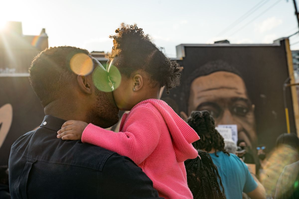 OJ Adeyemi and daughter Adenike listen to people speak before they march through the streets after the verdict was announced for Derek Chauvin on April 20, 2021, in Atlanta.