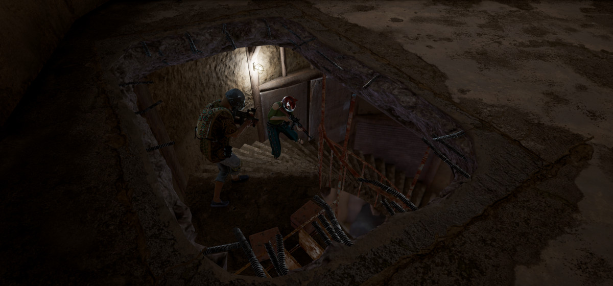 Two players walk down a staircase on PUBG’s Karakin with a hole in the ceiling above them