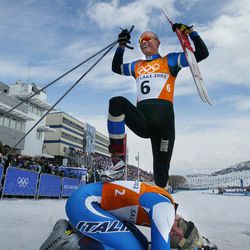 Norway's Tor Arne Hetland celebrates winning the gold medal in the men's sprint by standing over Italy's bronze-medal winner Cristian Zorzi at Soldier Hollow, Feb. 19, 2002. 