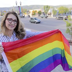 Heber City Mayor Kelleen Potter poses for a portrait in front of pride flags hanging on Main Street in Heber City on Monday, June 10, 2019.