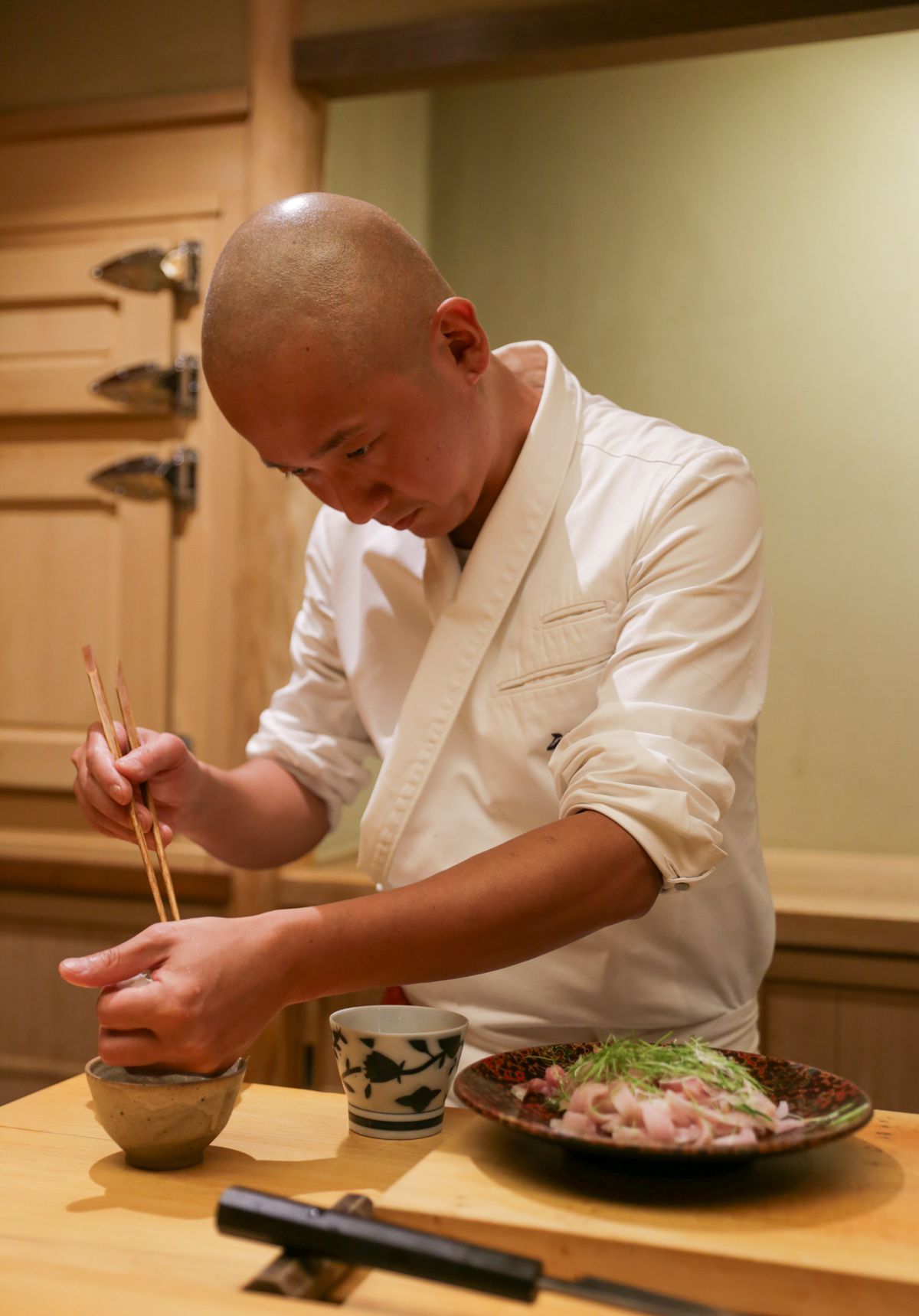 Nozumu Abe, chef of Sushi Noz, assembling a dish at his New York City restaurant.