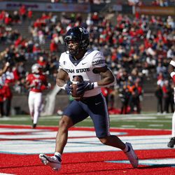 Utah State wide receiver Deven Thompkins (13) scores a touchdown against New Mexico during the first half of an NCAA college football game on Friday, Nov. 26, 2021, in Albuquerque, N.M. 