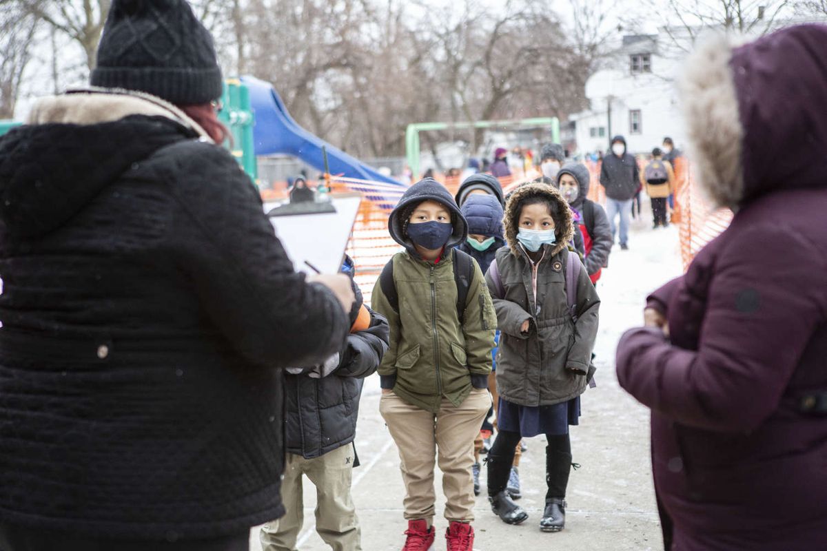 Students line up to enter school wearing masks