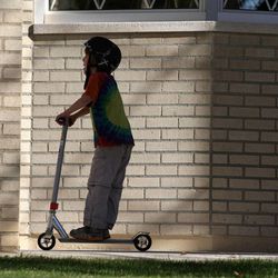 Ben Owen rides a scooter across the street from his home on Thursday, Oct. 30, 2014, in Salt Lake City. Ben was diagnosed with autism spectrum disorder at age 2. His father, Jon Owen, is president of the Utah Autism Coalition.