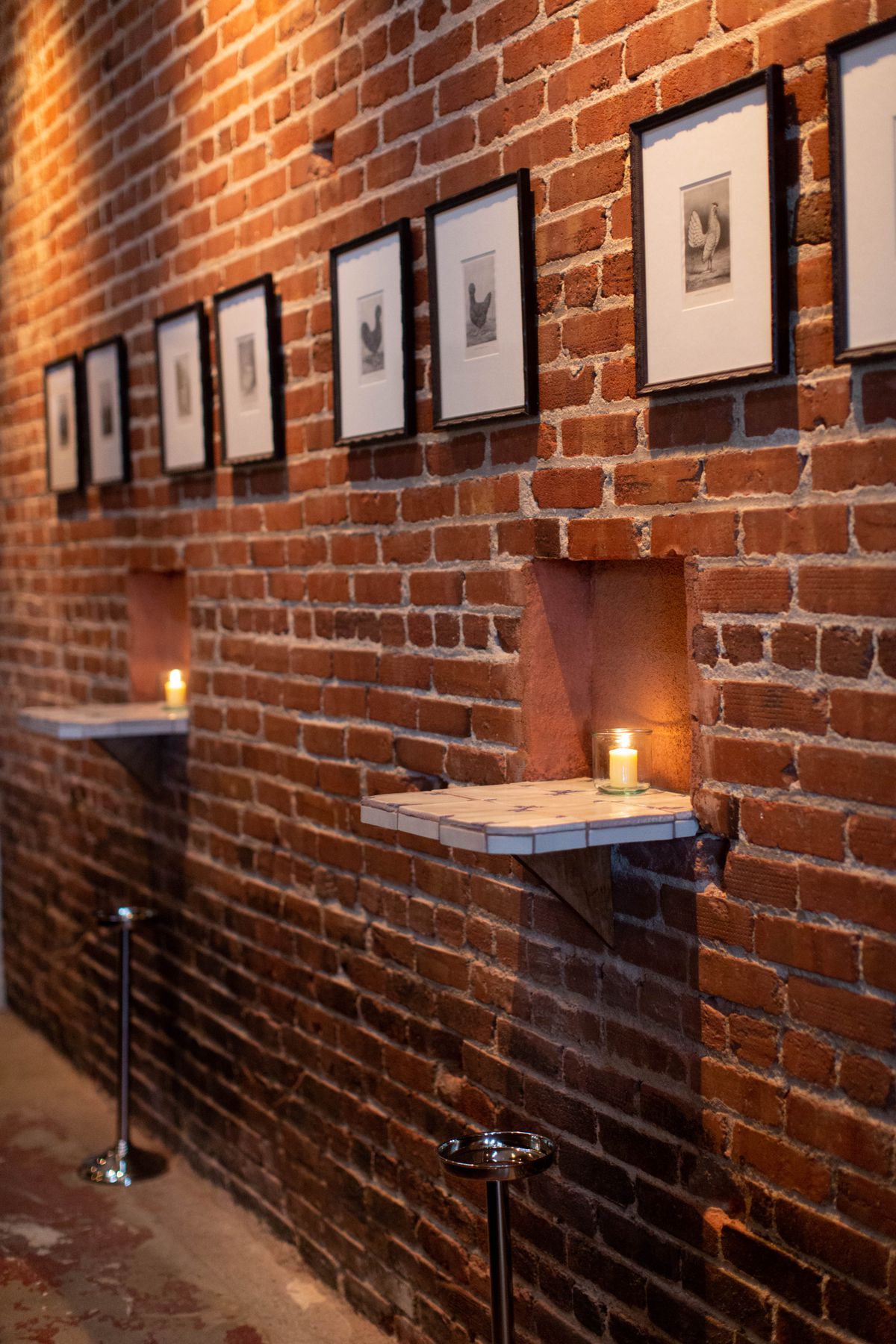 A brick wall with nooks for holding drinks in a new restaurant.