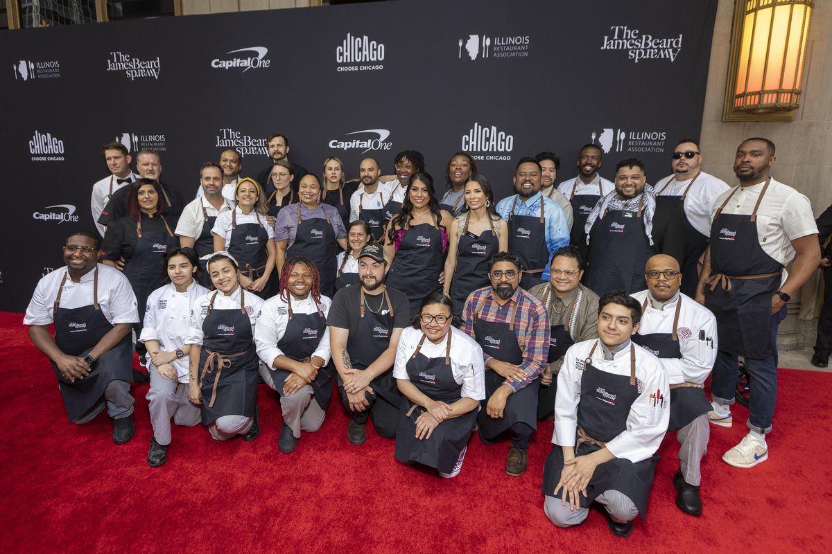A group of students wearing chef whites and aprons gathers on the red carpet at the James Beard Awards.