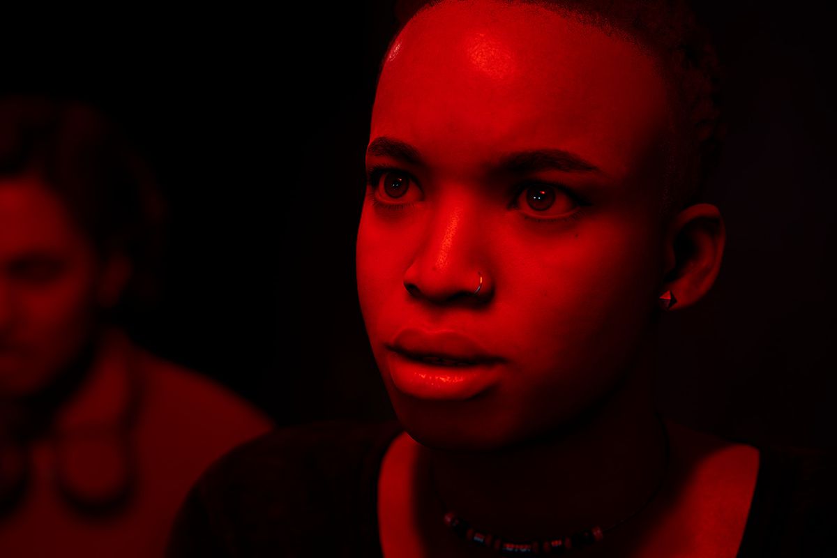 The Devil In Me - Two people, a Black man and woman, look worried and concerned. The camera is close up on their faces, which are under a red light.