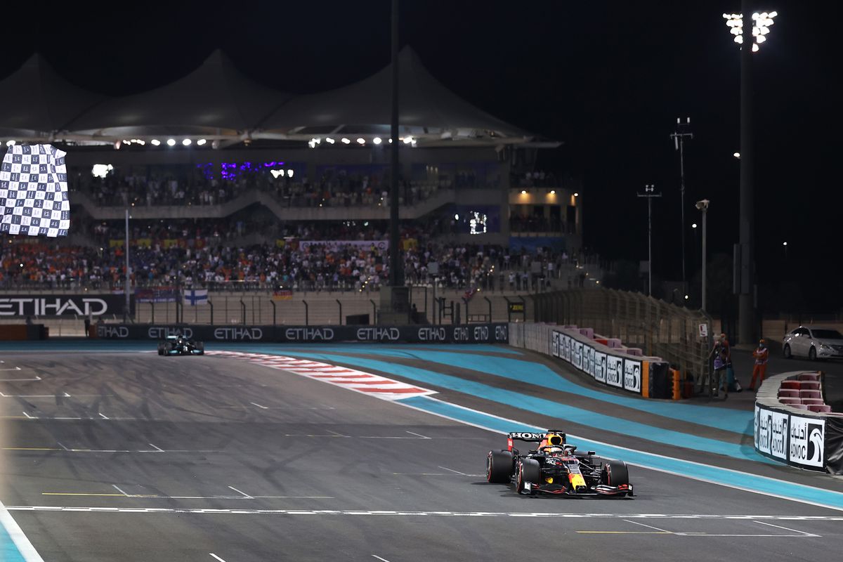 Race winner Max Verstappen of the Netherlands driving the (33) Red Bull Racing RB16B Honda takes the chequered flag during the F1 Grand Prix of Abu Dhabi at Yas Marina Circuit on December 12, 2021 in Abu Dhabi, United Arab Emirates.