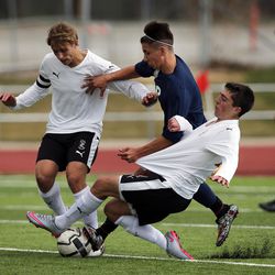 Weston Huber, left, and Matt Penrod, right, of Viewmont work against Joshua Ubico of Hunter to control the ball during high school soccer played in Bountiful, Wednesday, March 23, 2016.