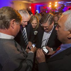 Salt Lake County Sheriff Jim Winder and Salt Lake County District Sim Gill and others look at numbers as Democrats gather Tuesday, Nov. 4, 2014, in Salt Lake City. 