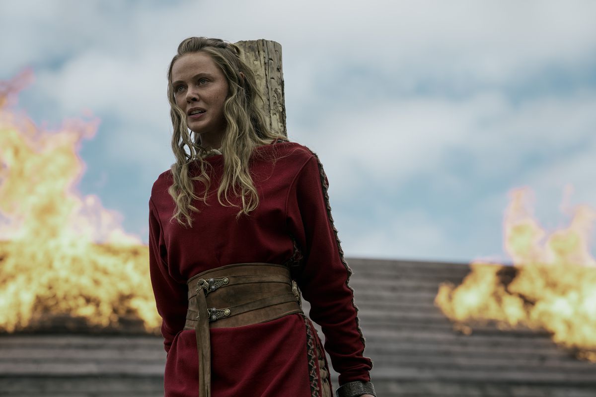Frida Gustavsson appears to be tied to a wooden stake while fire burns in the background in Vikings: Valhalla