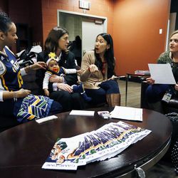 Shivolli DaSilva, left, Linda Luchetti, Kari Larson and Brooke Blonquist talk at Vivint Arena in Salt Lake City, Friday, Feb. 19, 2016, as Linda holds Shivolli's daughter Sanaa Favors.
