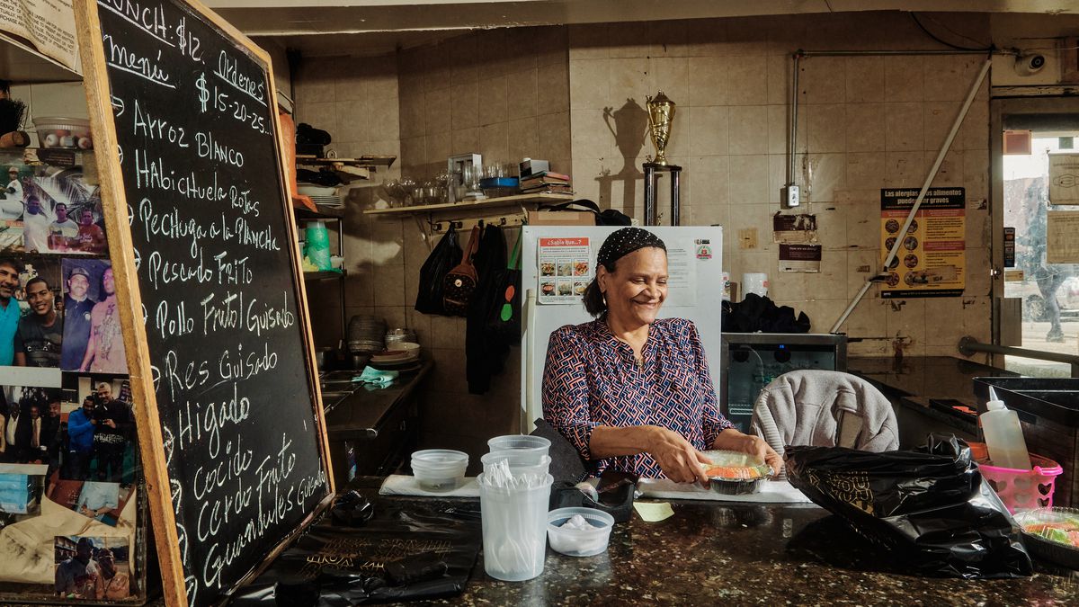 A woman behind the bar who cooks Dominican food.