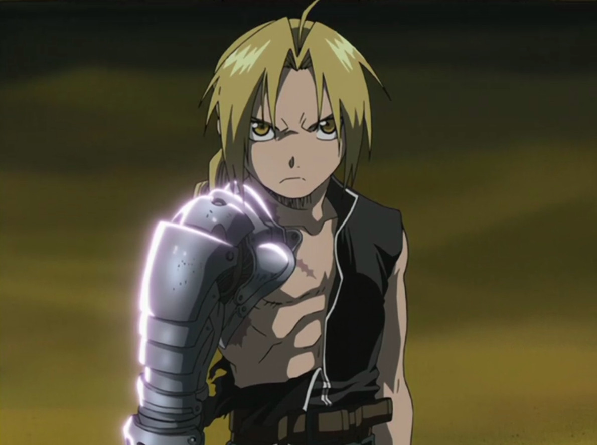Edward Elric, from the original Fullmetal Alchemist series, stands on a sand floor. His red jacket is gone and half of his shirt has been ripped off, exposing his chest and automail arm. He looks angry and determined, but calm.