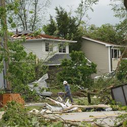 Residents survey the damage on Janes Avenue near Evergreen Lane in Woodridge after a tornado ripped through the western suburbs overnight, Monday morning, June 21, 2021.