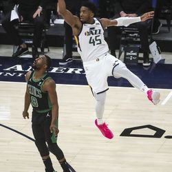 Utah Jazz guard Donovan Mitchell (45) hangs in the air after shooting a three-pointer over Boston Celtics guard Kemba Walker (8) during the Boston Celtics at Utah Jazz NBA basketball game at Vivint Smart Home Arena in Salt Lake City on Tuesday, Feb. 9, 2021.