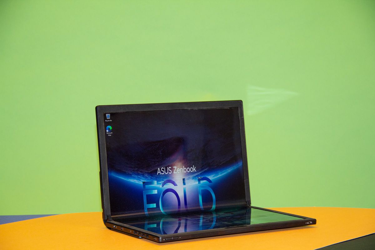 The Asus Zebook 17 Fold OLED in laptop mode, angled to the right. The screen displays the Asus Zenbook Fold OLED logo on a blue background.