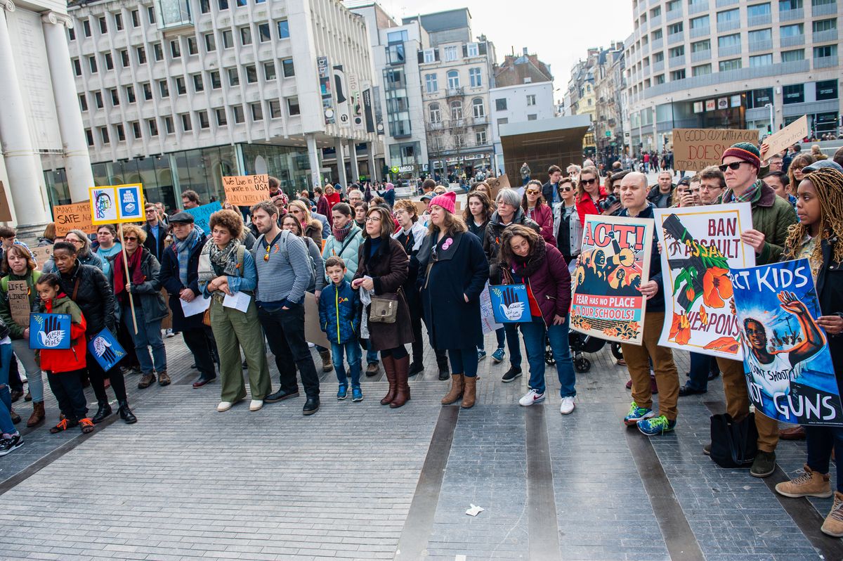 March for Our Lives protesters in Brussels, Belgium carry signs reading “Protect Kids, Not Guns” and “Ban Assault Weapons.”