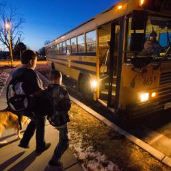 Dawn Voss helps her son Britton and his service dog Dopey to the school bus in Clearfield on Monday, Dec. 19, 2016.