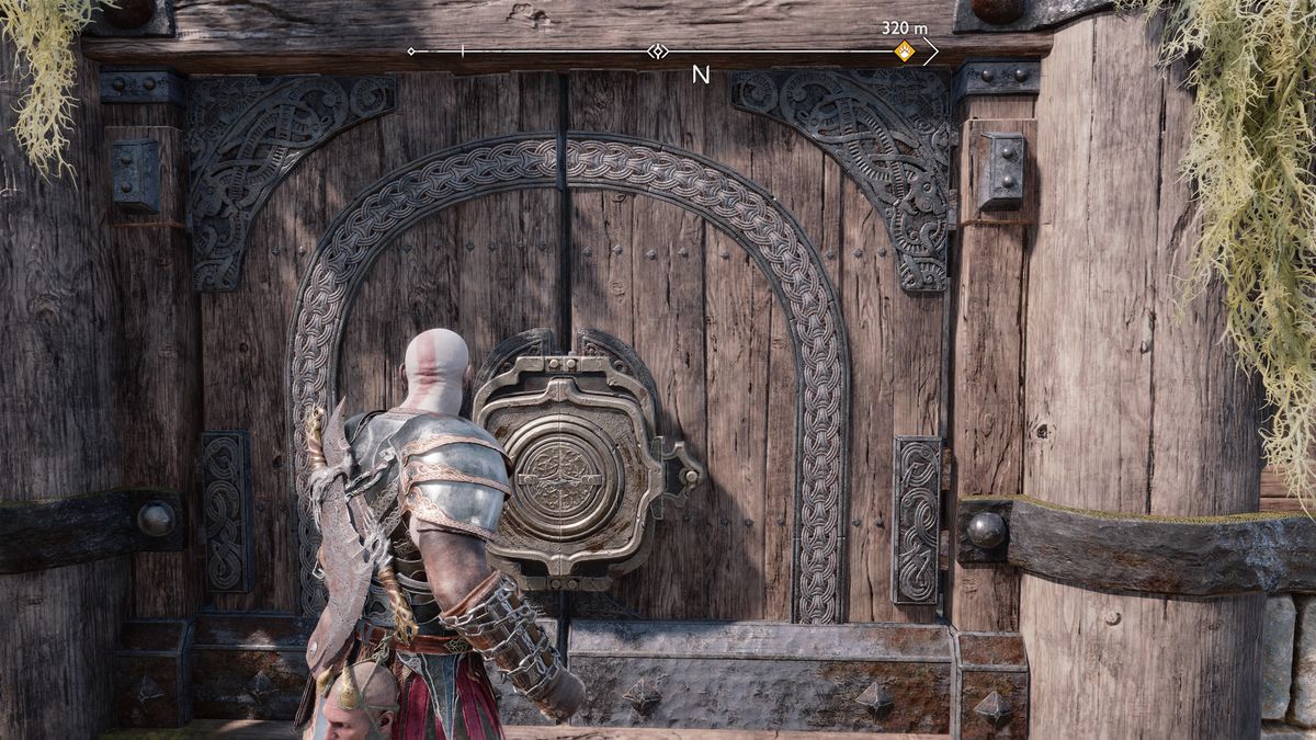 Kratos opens a big metal door in God of War Ragnarök