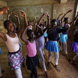 In this photo taken Friday, Dec. 9, 2016, young ballerinas receive instruction from Kenyan ballet dancer Joel Kioko, 16, in a room at a school in the Kibera slum of Nairobi, Kenya. In a country not usually associated with classical ballet, Kenya's most promising young ballet dancer Joel Kioko has come home for Christmas from his training in the United States, to dance a solo in The Nutcracker and teach holiday classes to aspiring dancers in Kibera, the Kenyan capital's largest slum. 