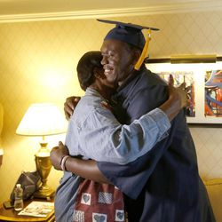 Ziggy Ansah embraces his mother while wearing his cap and gown in his New York City hotel room.