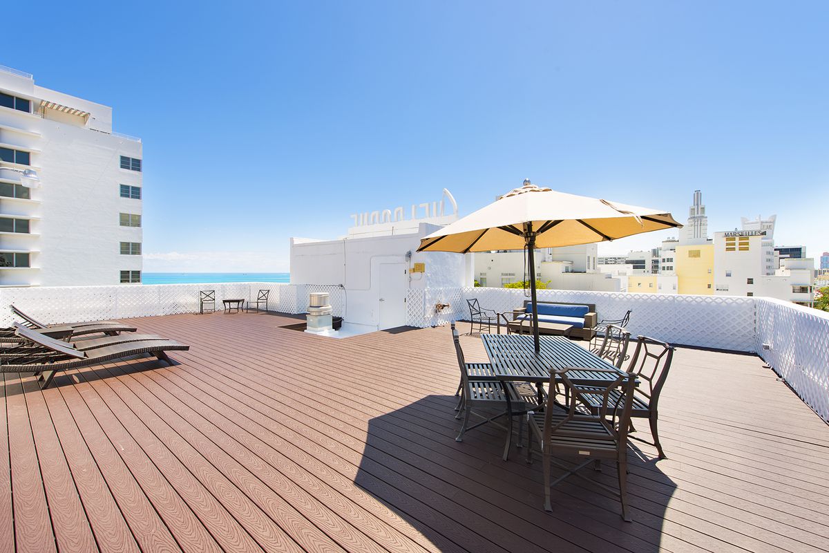 A rooftop wood deck at the top of a hotel in South Beach with an ocean view