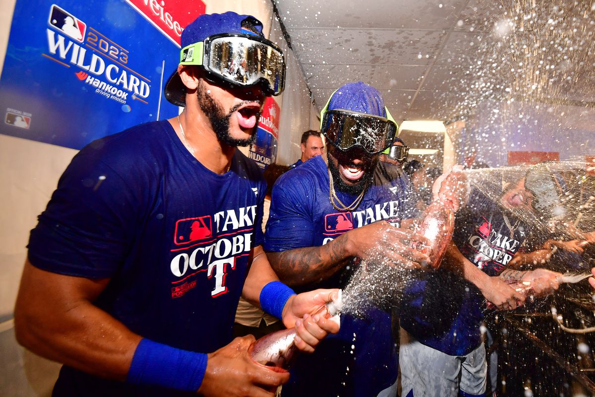 Leody Taveras and Adolis Garcia of the Texas Rangers celebrate in the clubhouse after defeating the Tampa Bay Rays 7-1 in Game Two of the Wild Card Series at Tropicana Field on October 04, 2023 in St Petersburg, Florida.