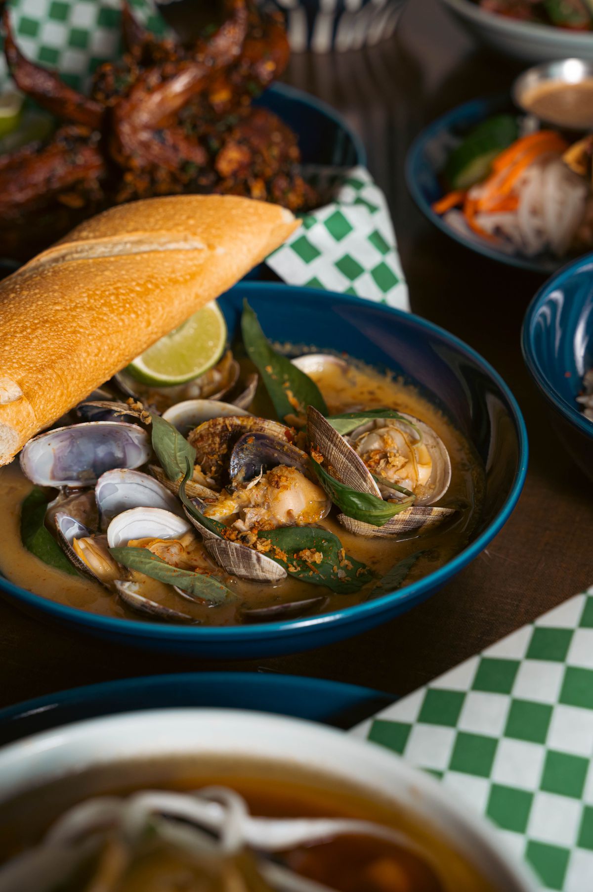 Curried clams&nbsp;with yellow curry, white ale, coconut, rau ram, and baguette.