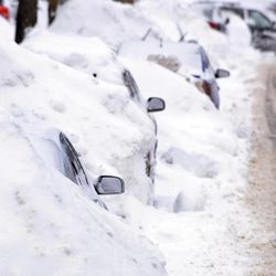 A line of cars sit buried in snow banks in Somerville, Mass., Tuesday, Feb. 10, 2015. The latest snowstorm left the Boston area with another two feet of snow and forced the MBTA to suspend all rail service for the day. 
