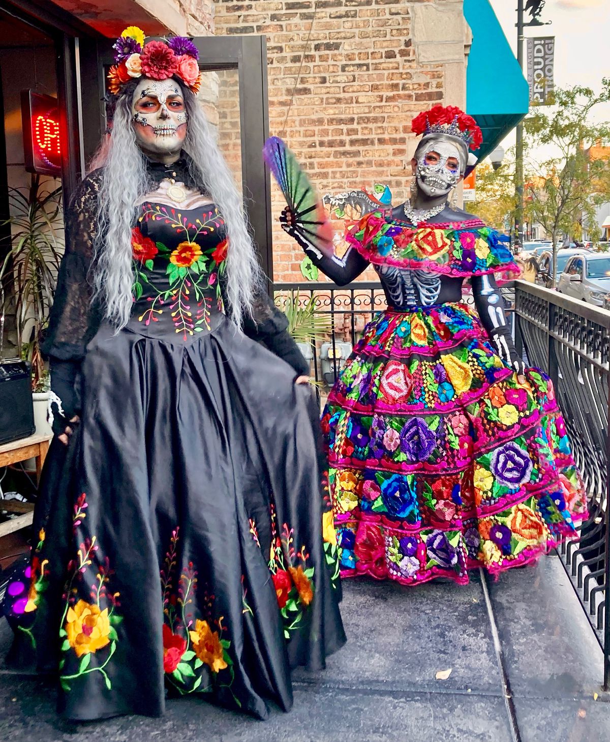Two men dressed as female Day of the Dead skeletons.