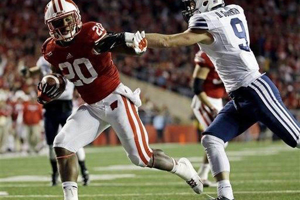 Wisconsin's James White (20) gets past Brigham Young's Daniel Sorensen (9) for a 14-yard touchdown run during the second half of an NCAA college football game on Saturday, Nov. 9, 2013, in Madison, Wis. Wisconsin won 27-17. (AP Photo/Morry Gash) 